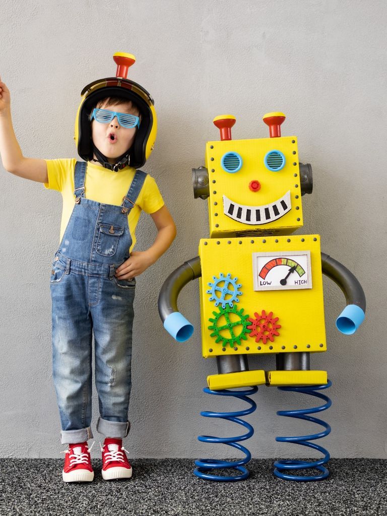 Eine Kursteilnehmerin steht neben einem selbstgebauten Roboter