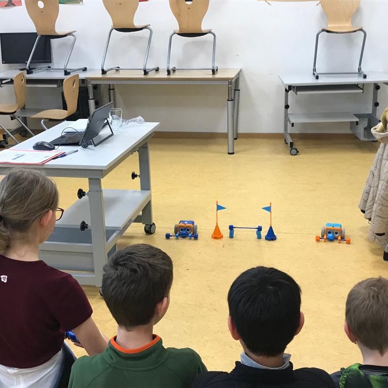 Kinder sehen kleine Roboter an